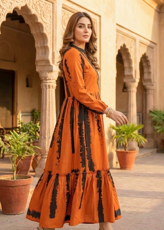 Woman in an orange dress standing in a courtyard with architectural columns and plants.