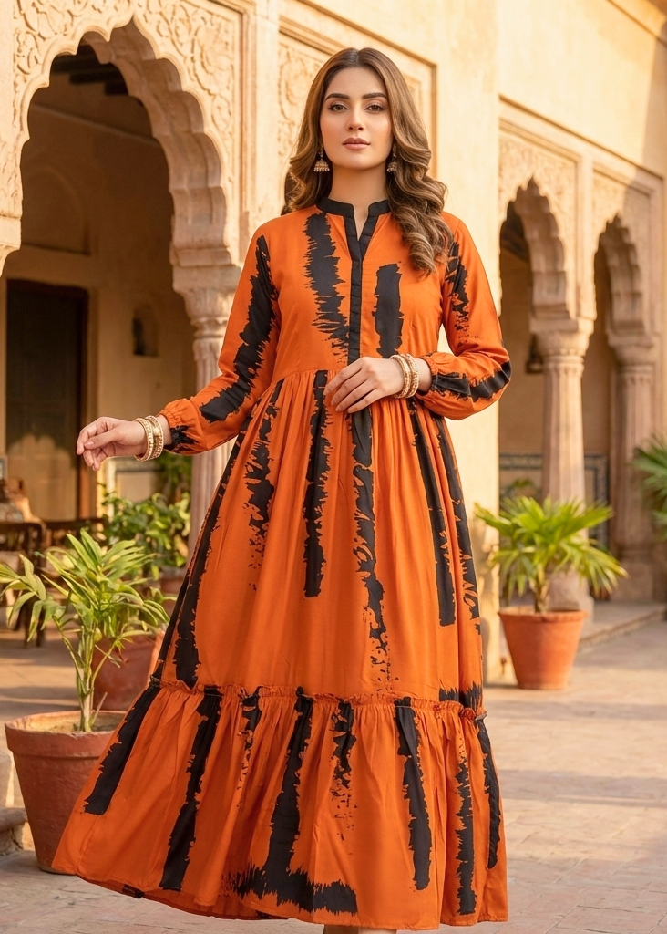 Woman in an orange dress with black patterns standing in a sunlit courtyard.
